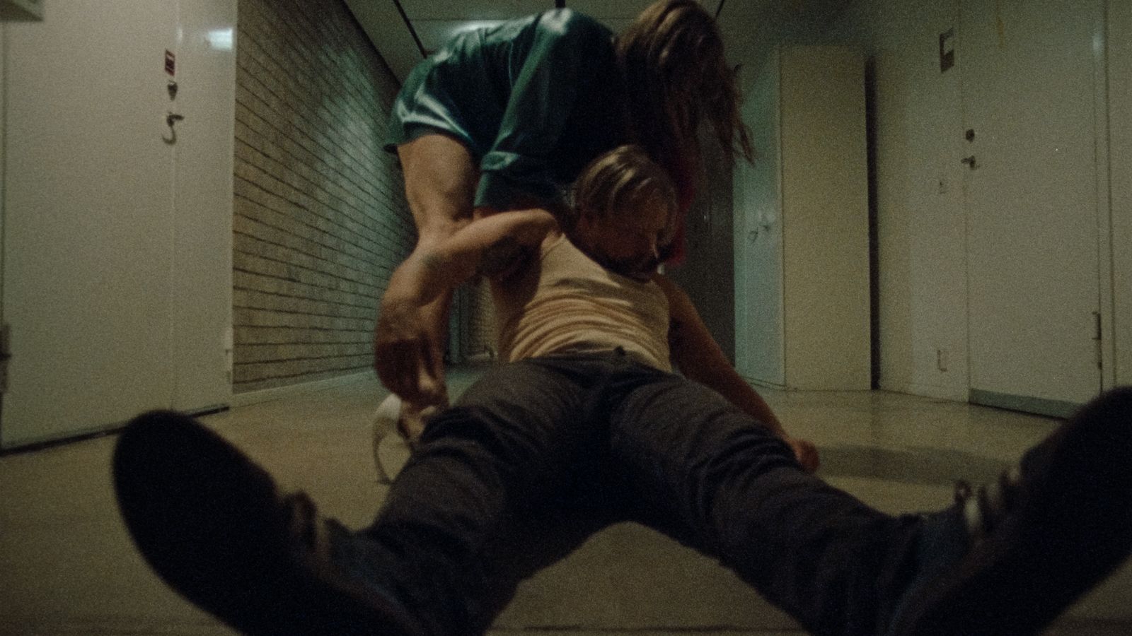 a man and a woman sitting on the floor in a hallway