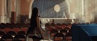 a woman standing in front of a room filled with chairs