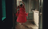 a woman in a red dress dancing in a doorway