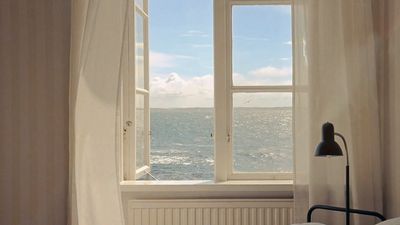 a bedroom with a large window overlooking the ocean