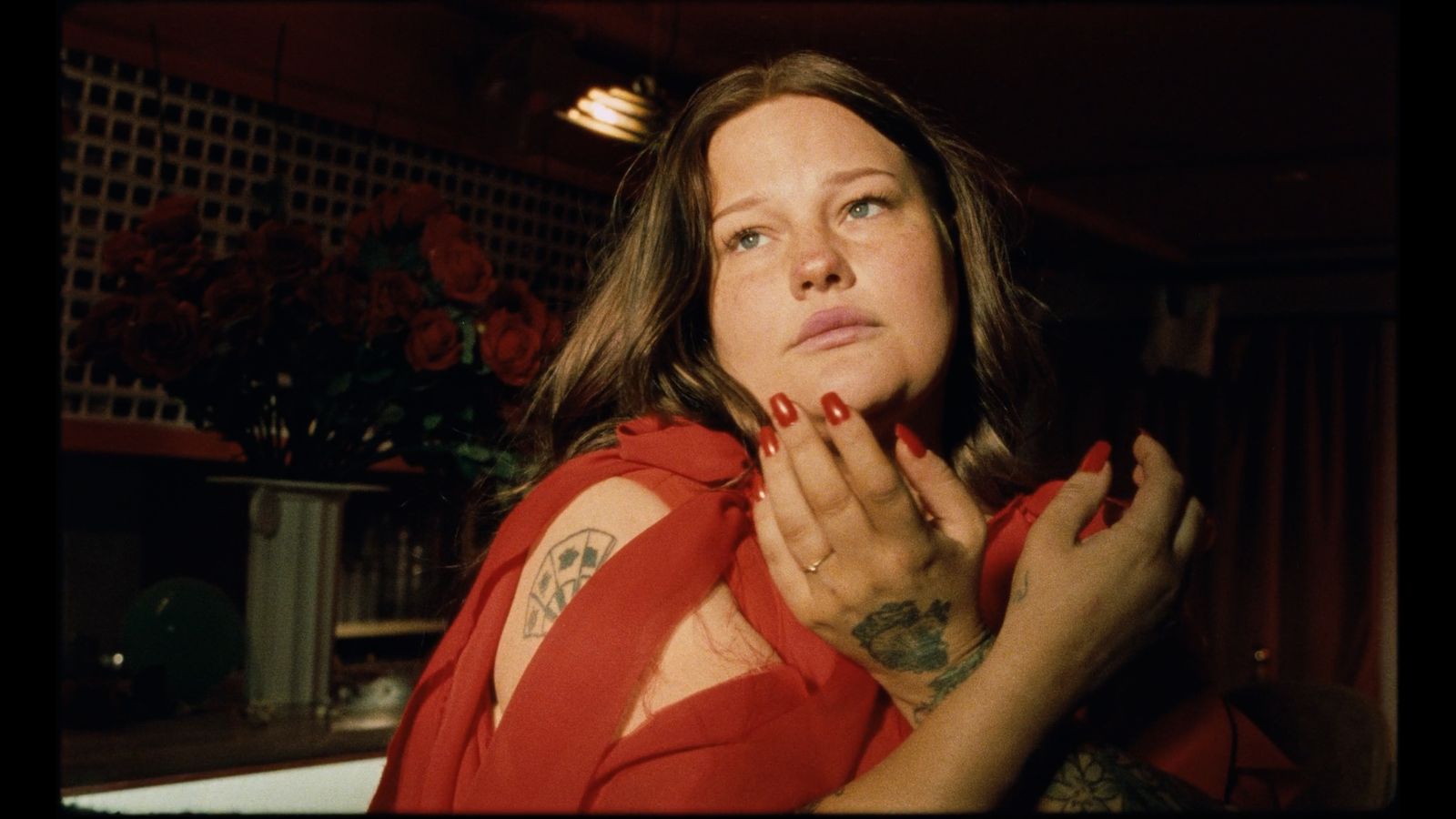 a woman in a red shirt with a tattoo on her arm