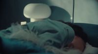 a person laying in a bed with a hat on