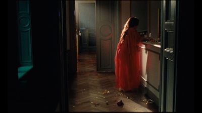 a woman in a red dress standing in a doorway