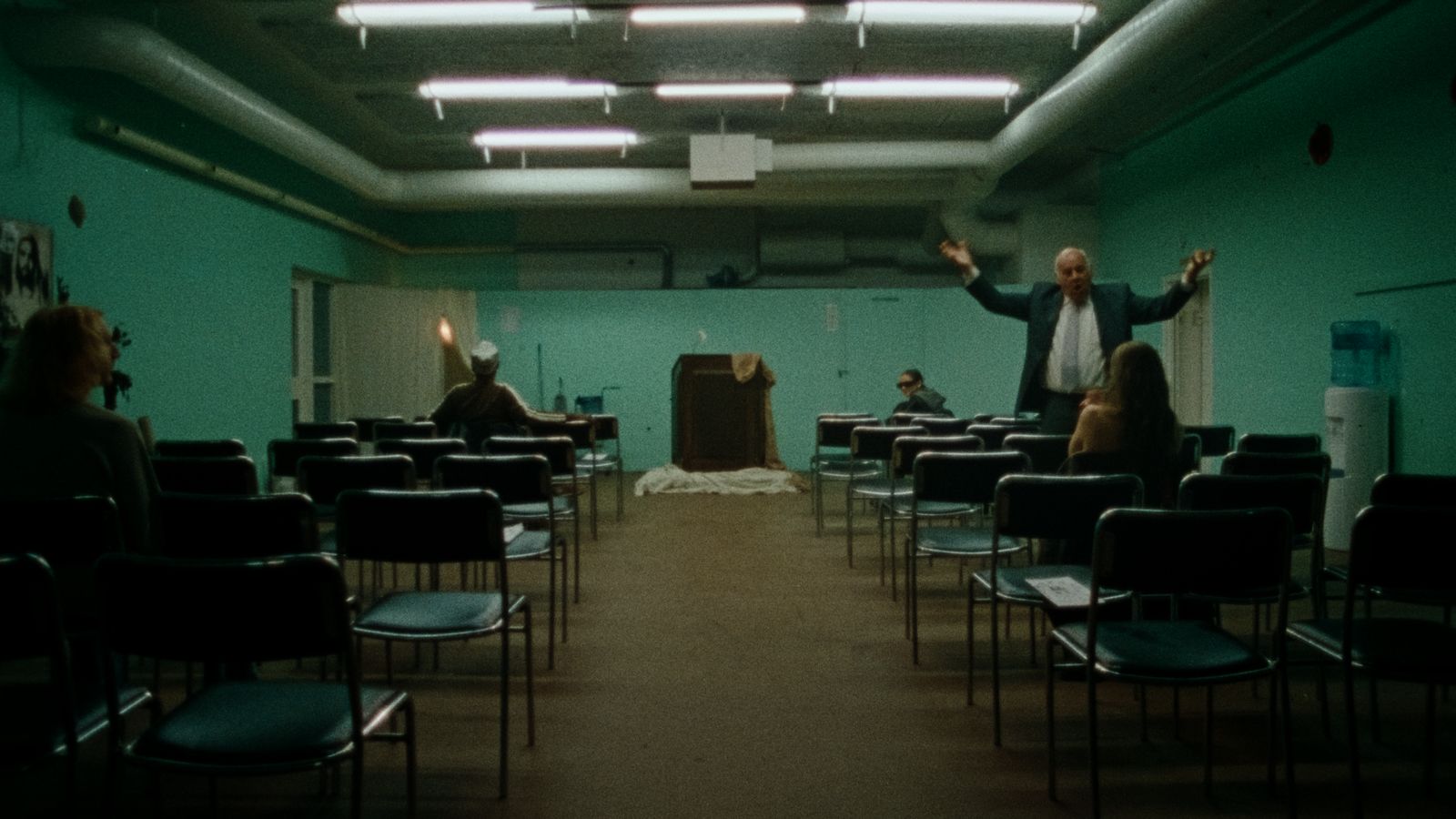 a man standing in front of a class room full of people