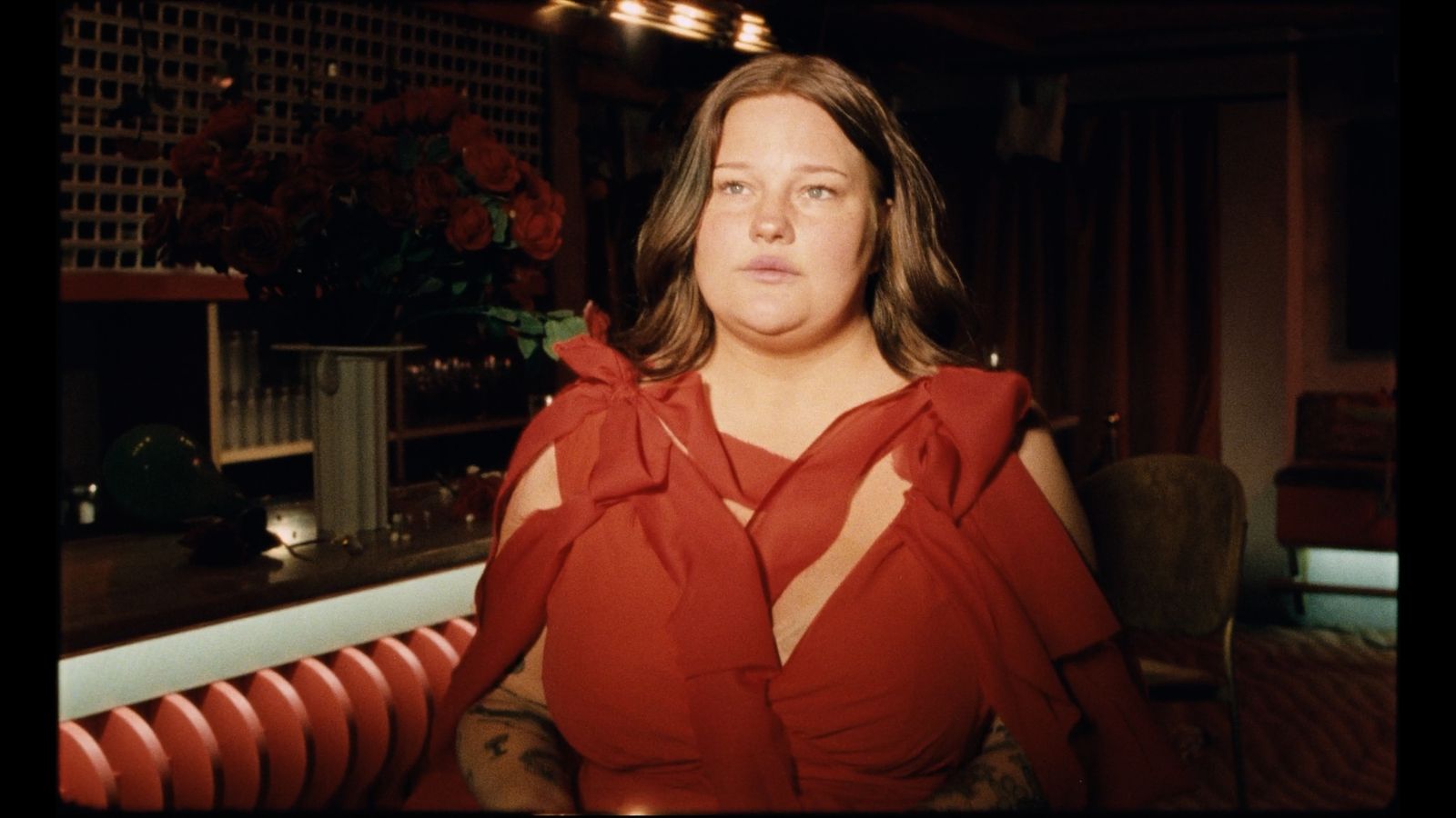 a woman in a red dress sitting in a chair