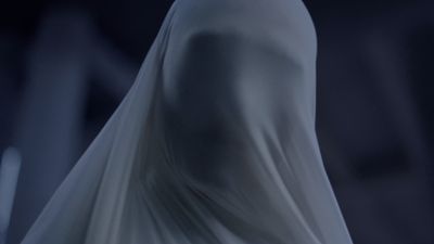 a woman in a white dress is standing in the dark