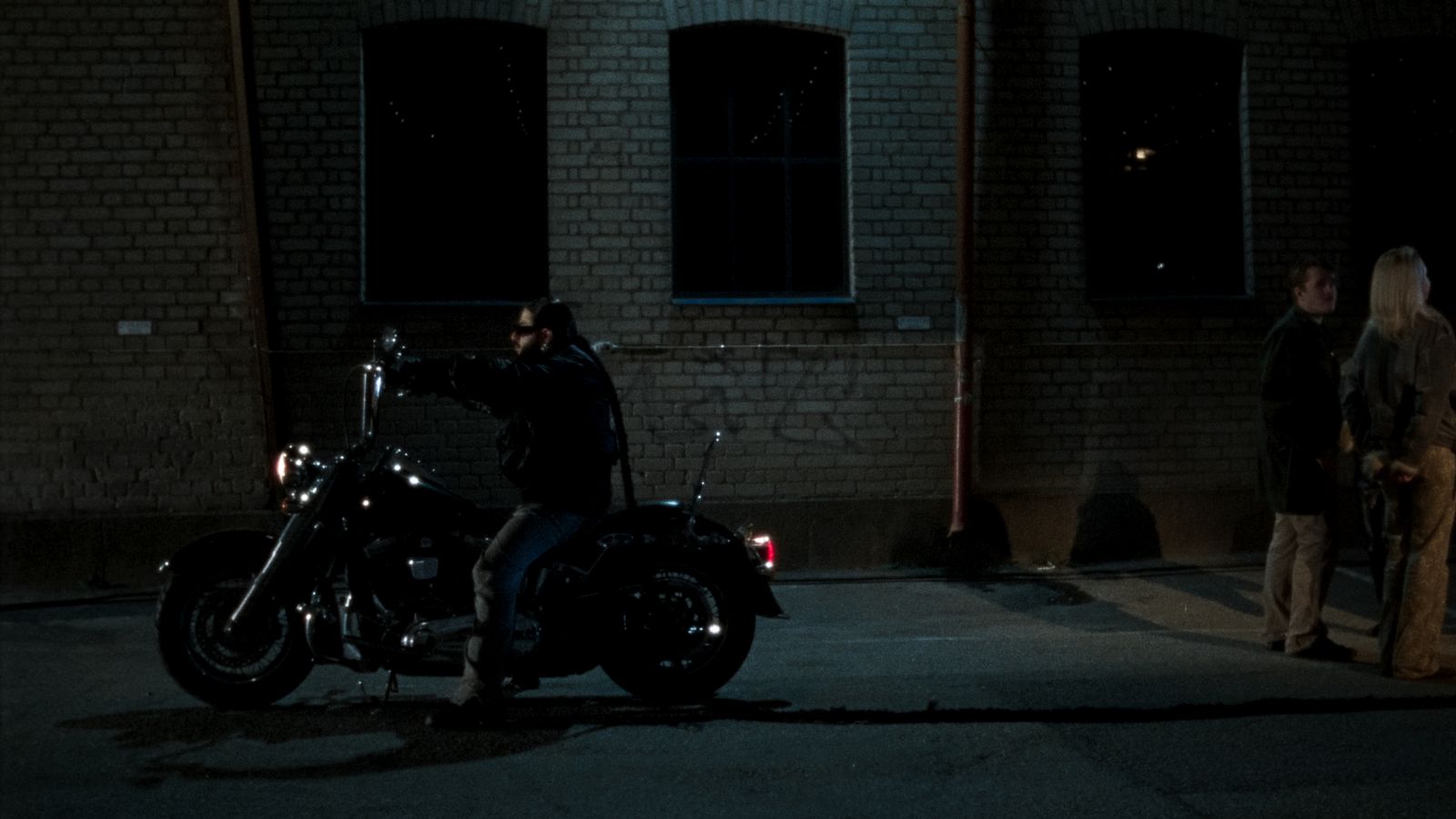 a man sitting on a motorcycle in the dark