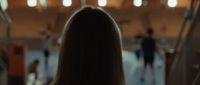 the back of a woman's head as she walks down an escalator