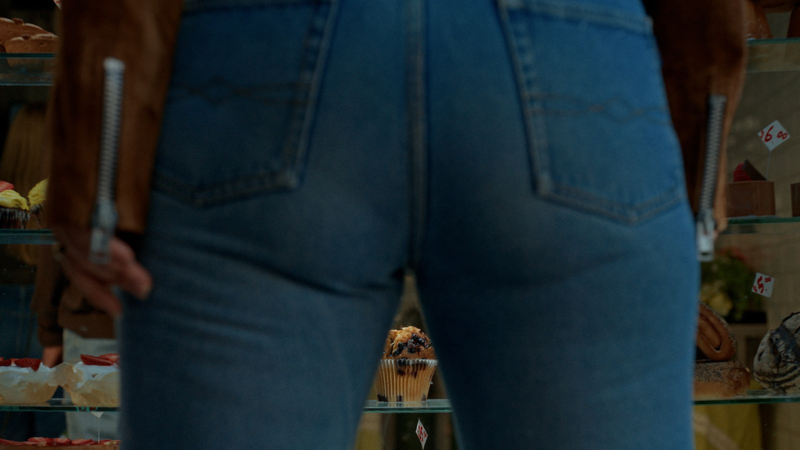 a person standing in front of a display of baked goods