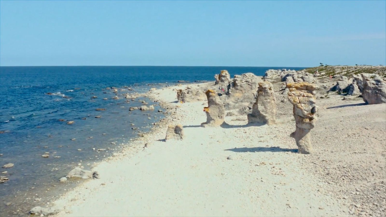 a sandy beach next to a body of water