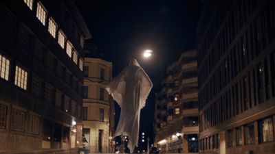 a ghost is walking down a city street at night