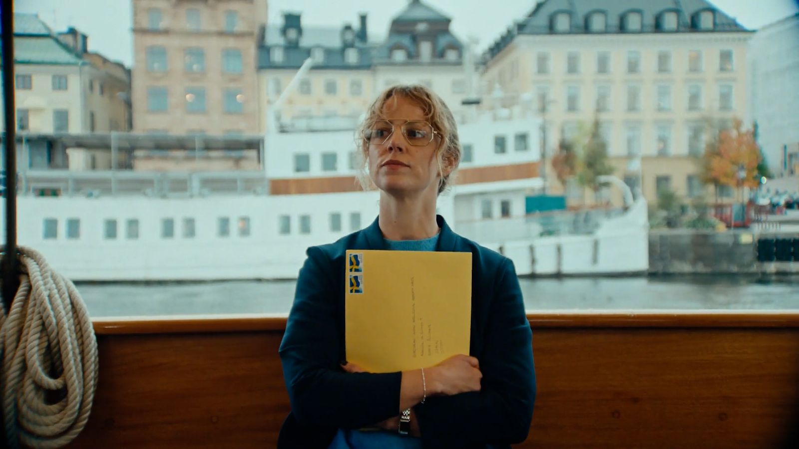 a woman sitting on a bench holding a yellow folder