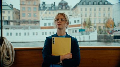 a woman sitting on a bench holding a yellow folder