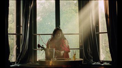 a woman in a red dress sitting in front of a window