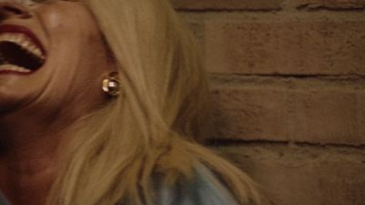 a woman laughing while holding a cell phone to her ear