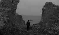 a man standing in the middle of a rocky area