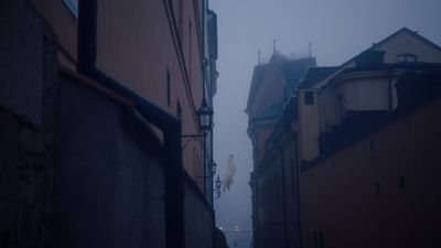 a foggy city street with buildings on both sides