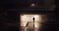 a person walking into a tunnel at night