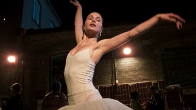 a woman in a white dress is dancing