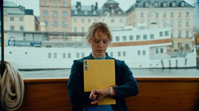 a woman sitting on a bench holding a yellow folder