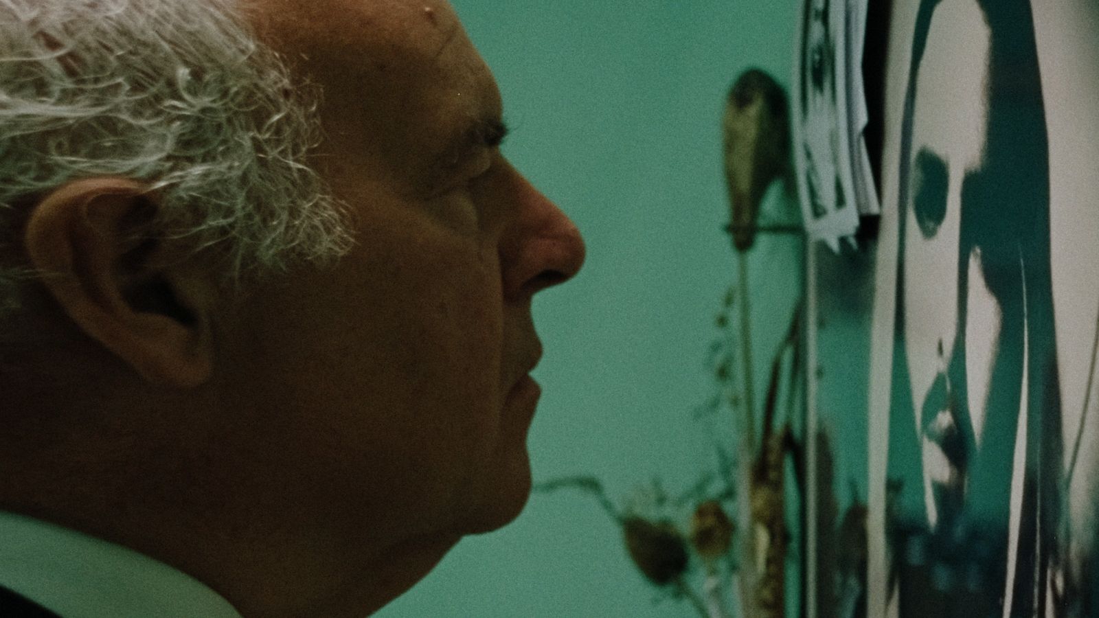 a man in a suit looking at a clock on a wall