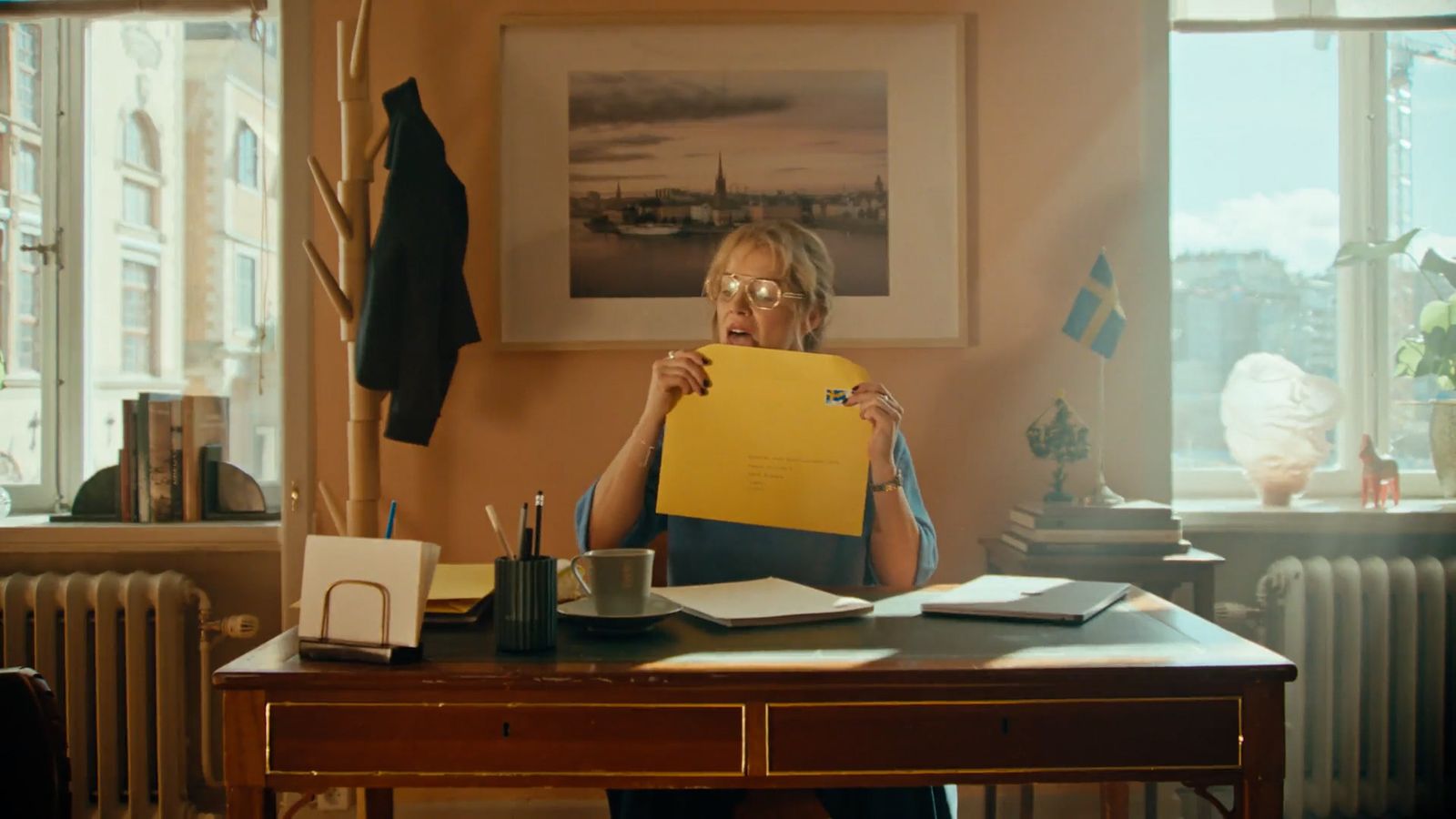 a woman sitting at a desk holding a piece of paper