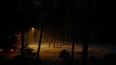 a group of people sitting on a bench at night