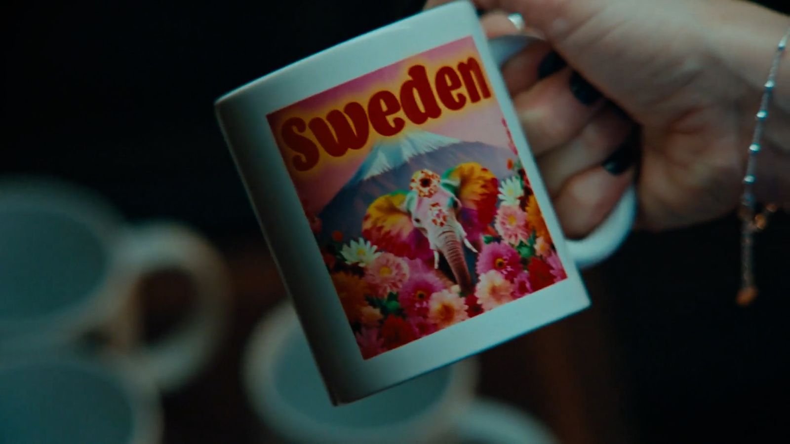 a person holding a coffee mug with a picture of sweden on it