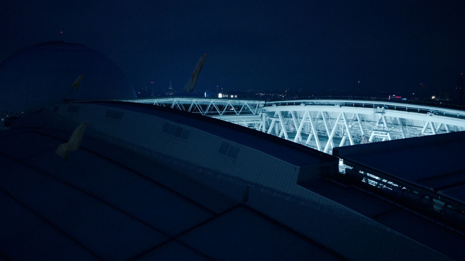 a view of a stadium at night from the roof of a building