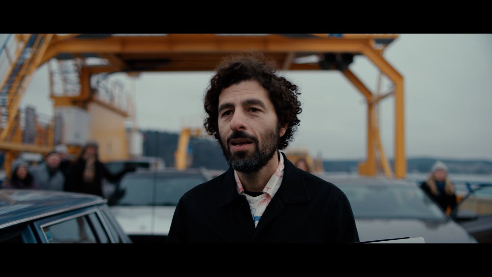 a man standing in front of a car in a parking lot