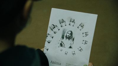 a person holding up a paper with a picture of jesus on it