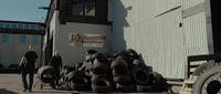 a man standing next to a large pile of tires