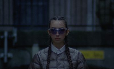 a woman with long braids wearing sunglasses