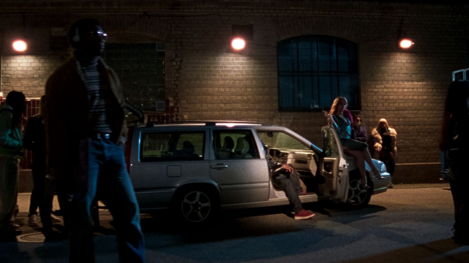 a group of people standing around a car