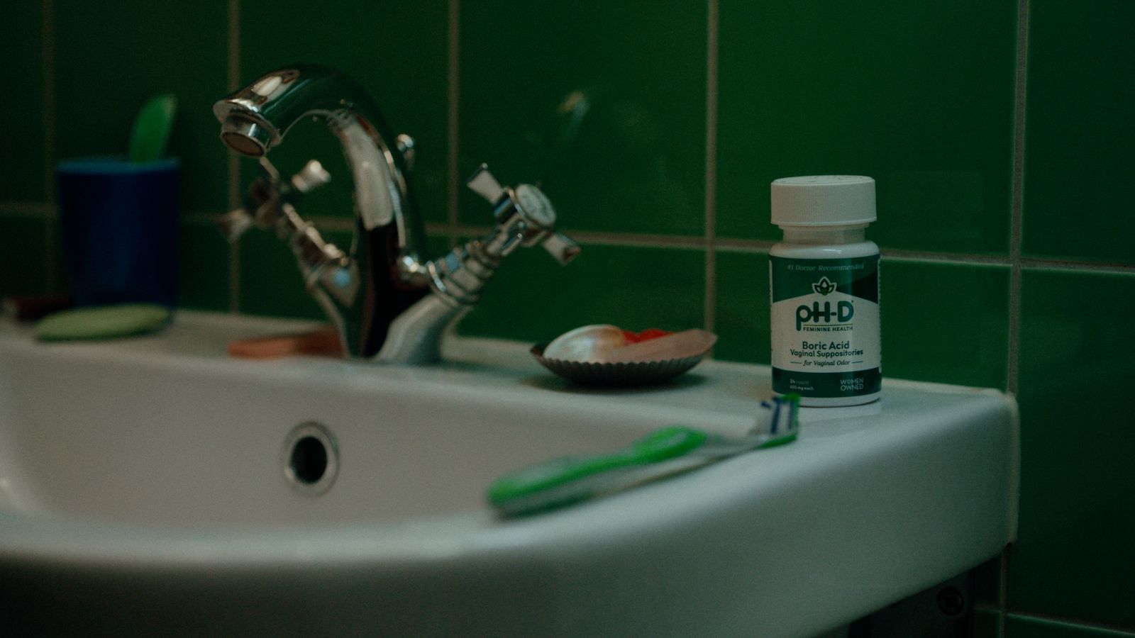 a bathroom sink with toothbrushes and toothpaste on it