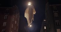 a ghost hanging from a building at night