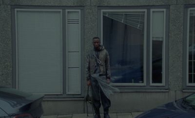 a man standing outside of a building next to a car