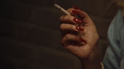 a woman holding a cigarette in her hand