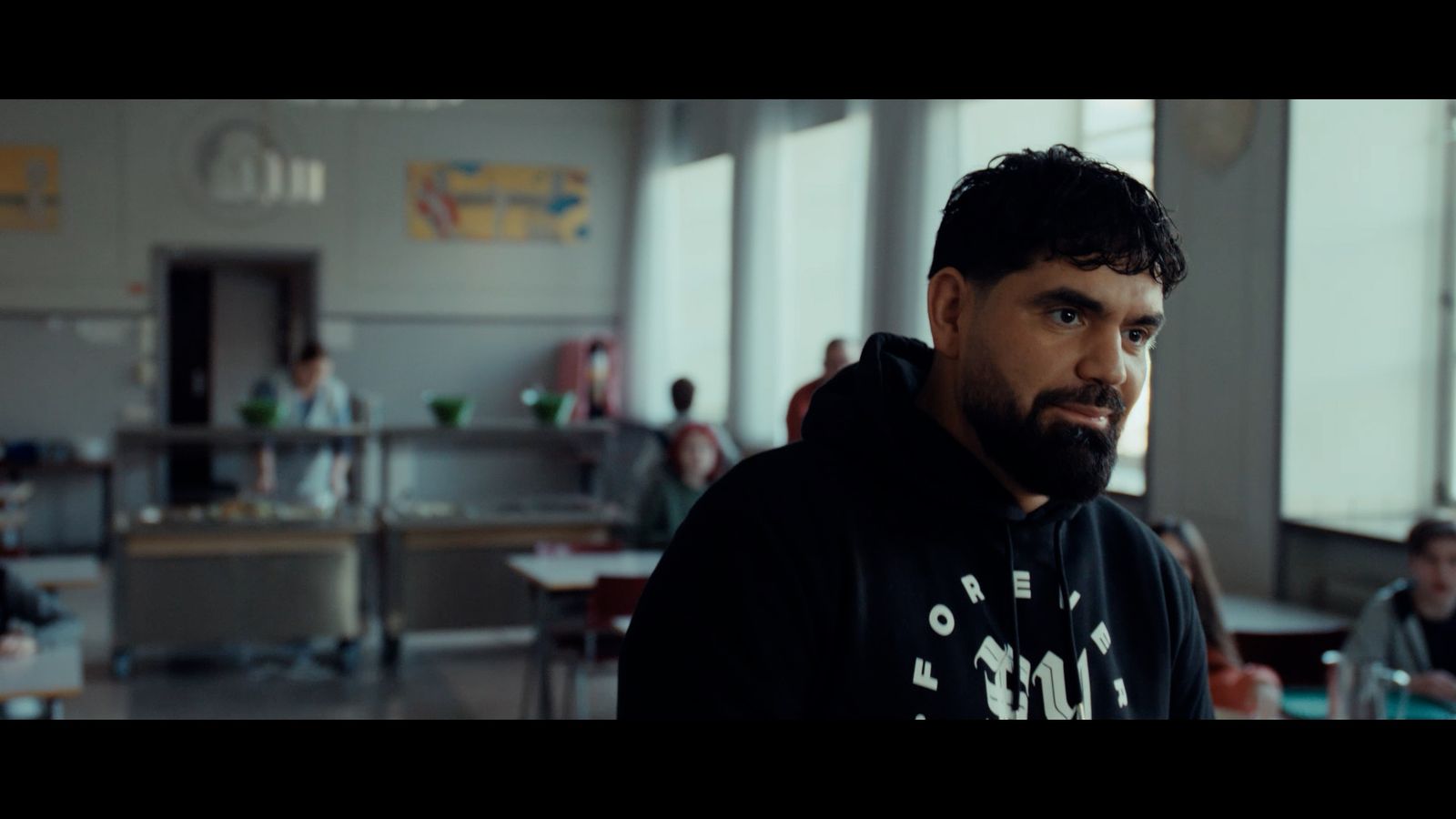 a man in a black hoodie standing in a room