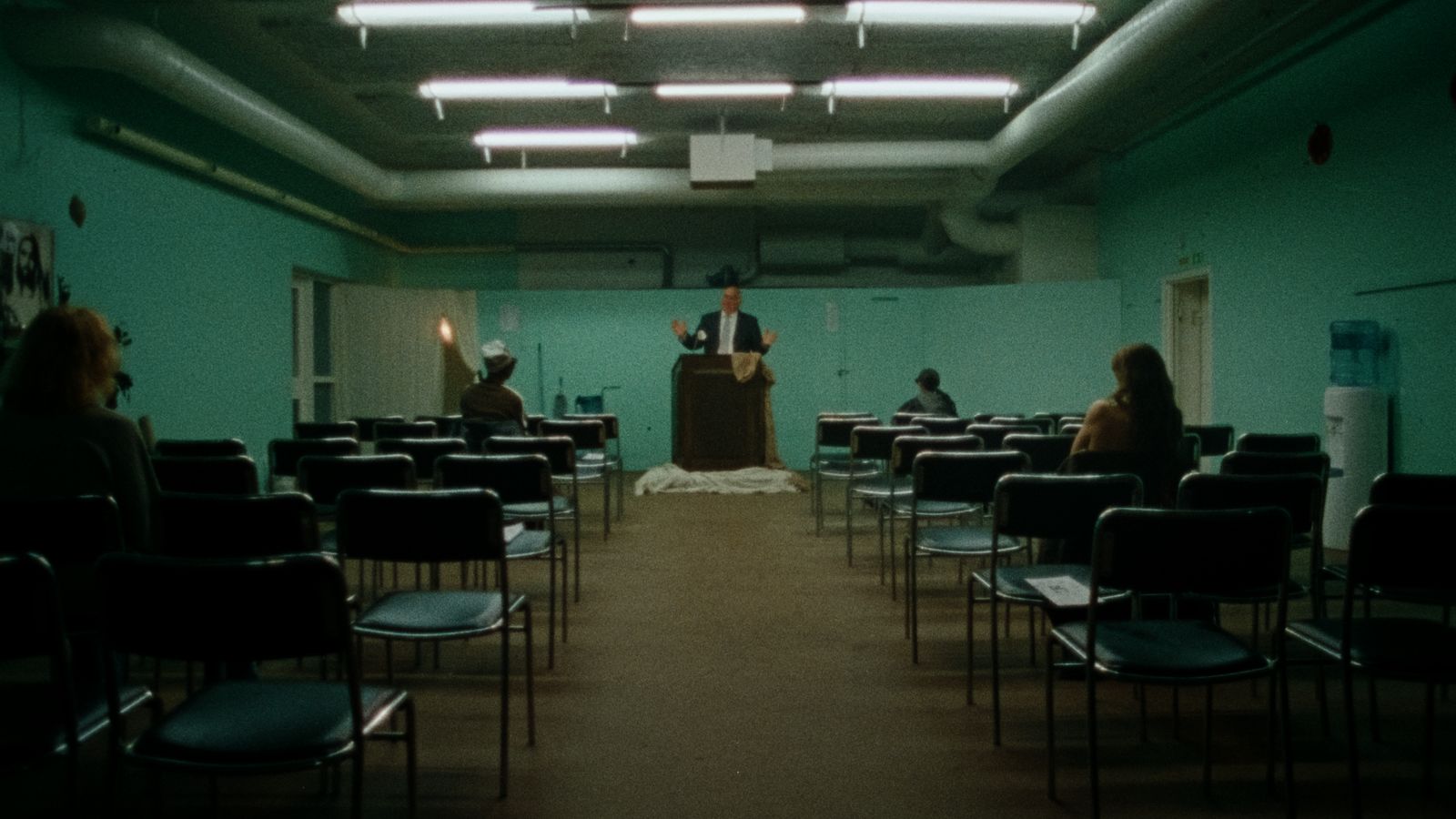 a man standing at a podium in front of a group of people