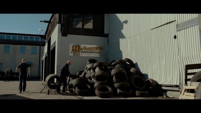 a man standing next to a pile of tires