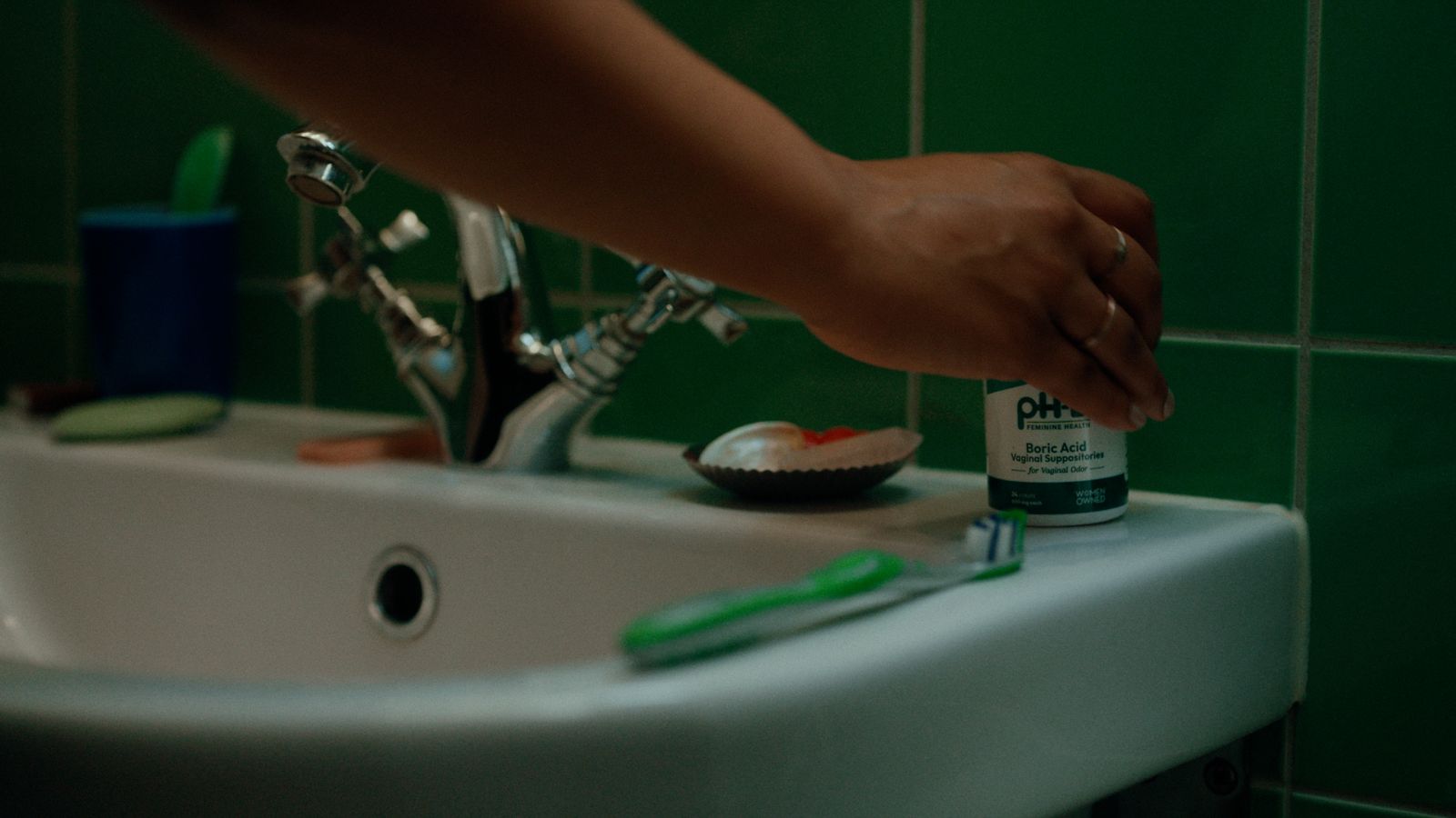 a person is putting toothpaste on a toothbrush