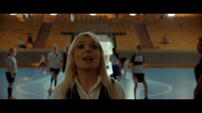 a woman with blonde hair standing in a gym