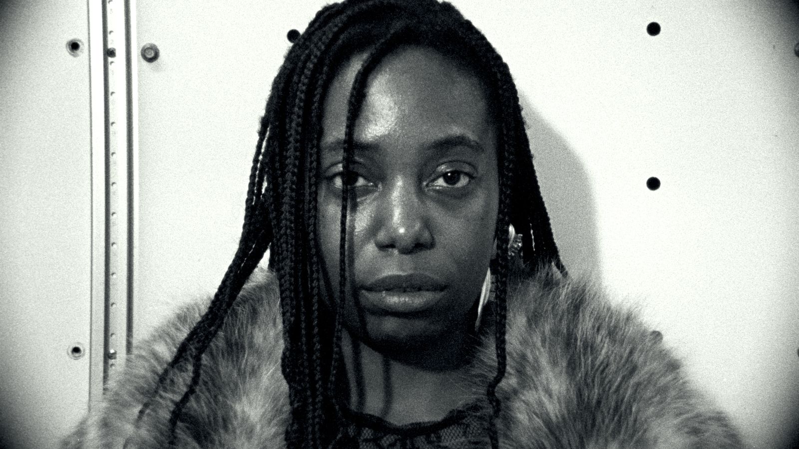 a black and white photo of a woman with dreadlocks