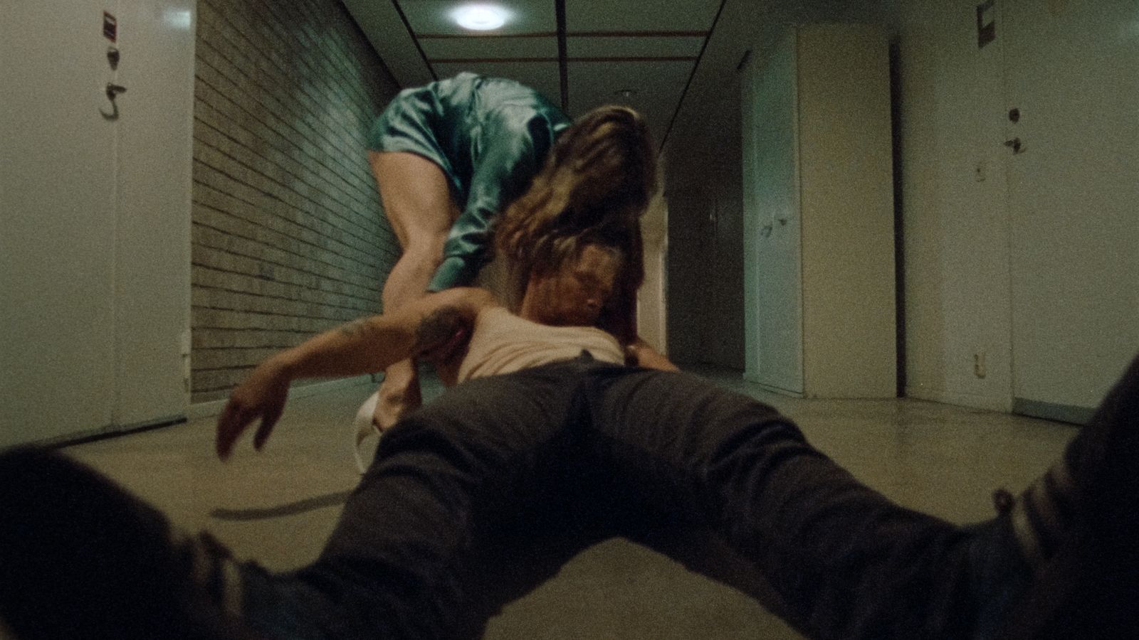 a man falling off his skateboard in a hallway