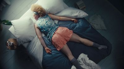 a woman laying on a bed with a pillow