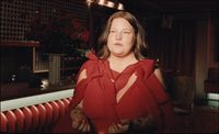 a woman in a red dress standing in a room