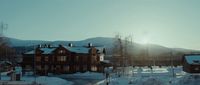 a house in the middle of a snowy field