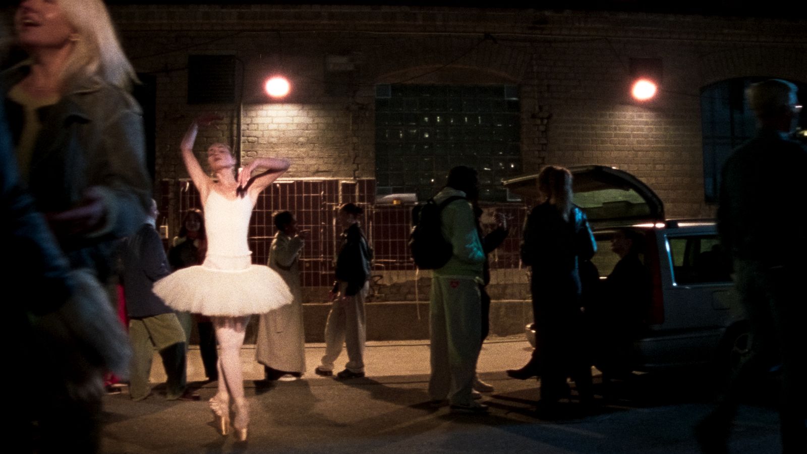 a woman in a white tutu dancing in front of a group of people