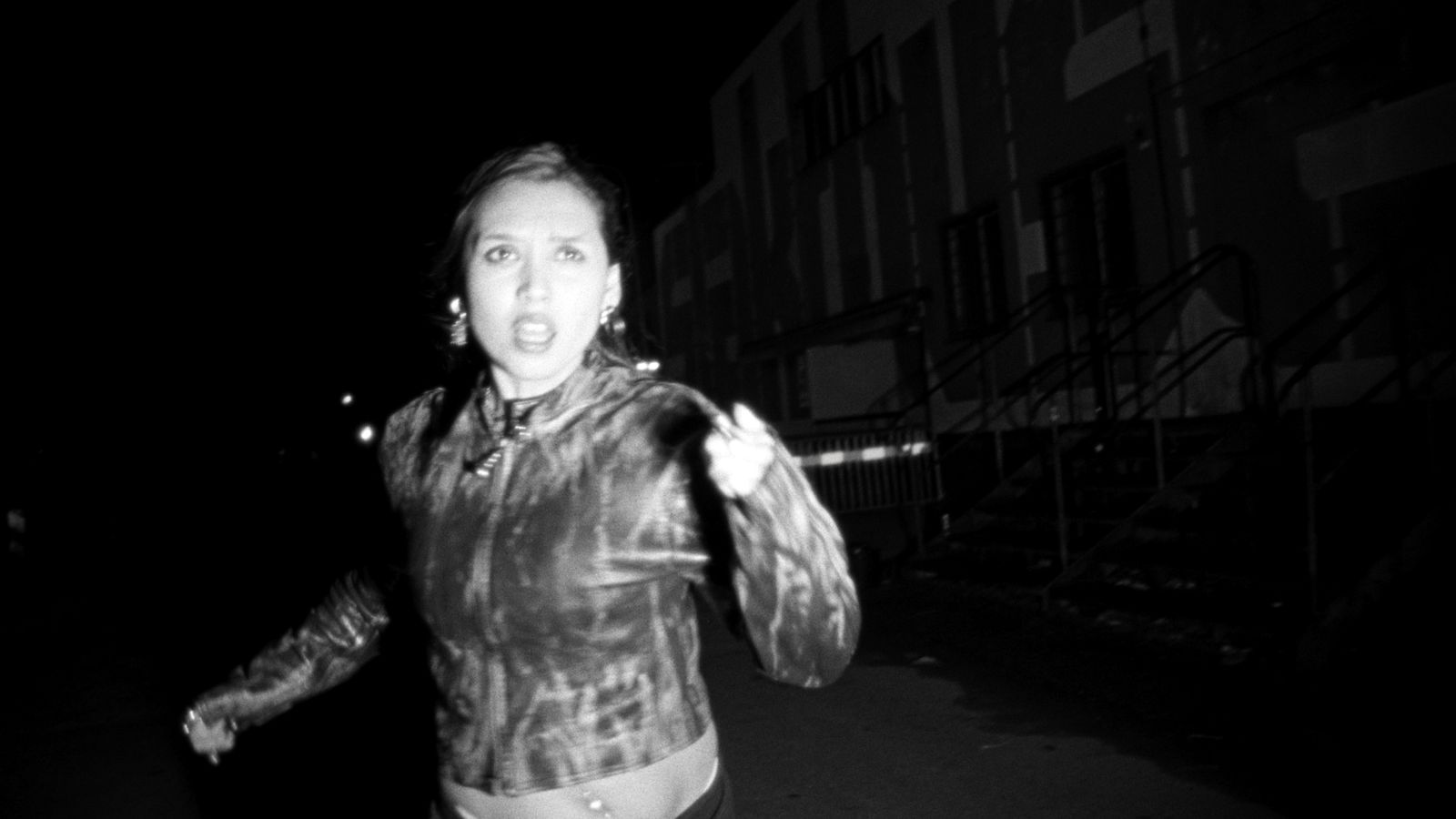 a woman walking down a street at night